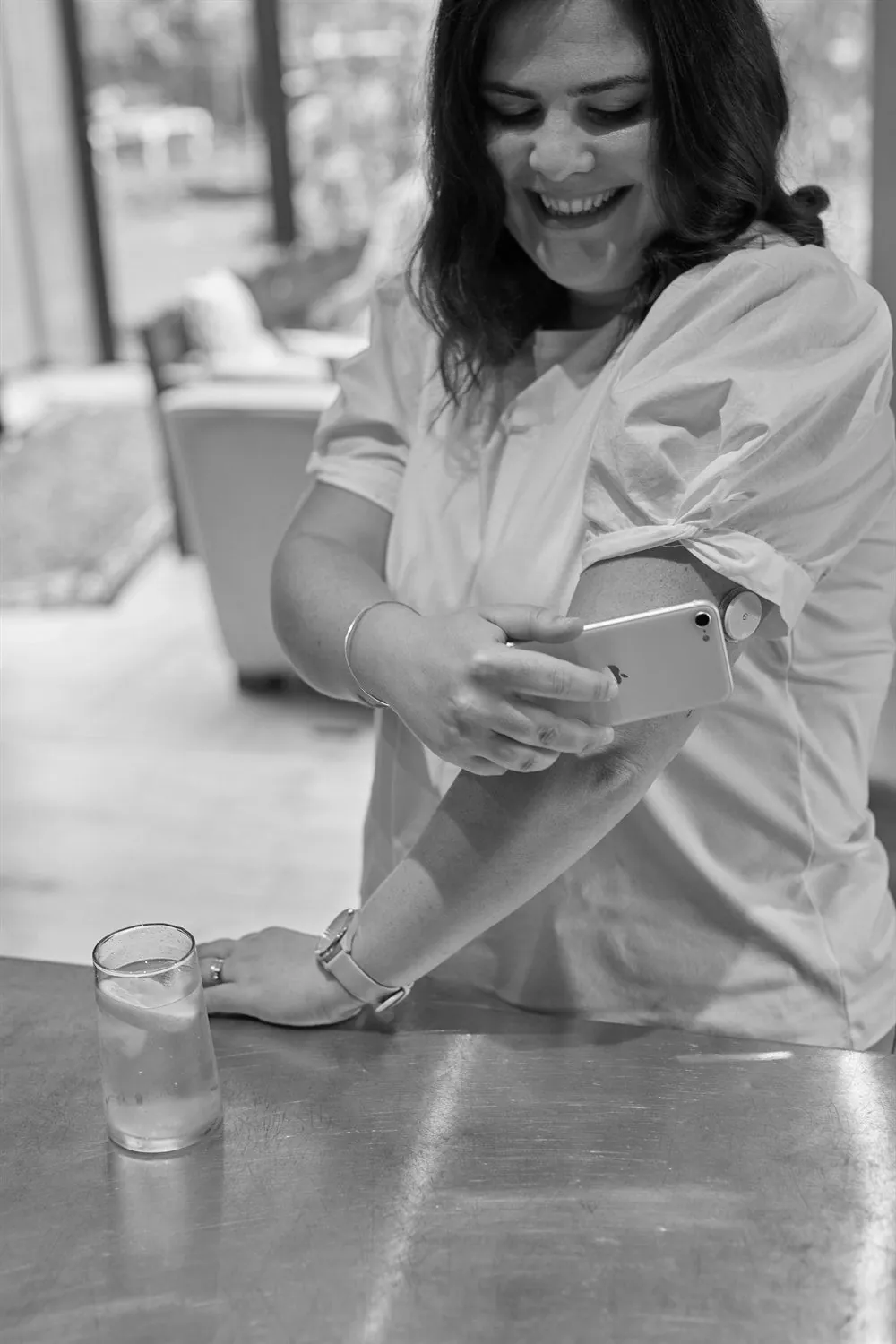 Woman scanning the glucose sensor on her arm with her smartphone